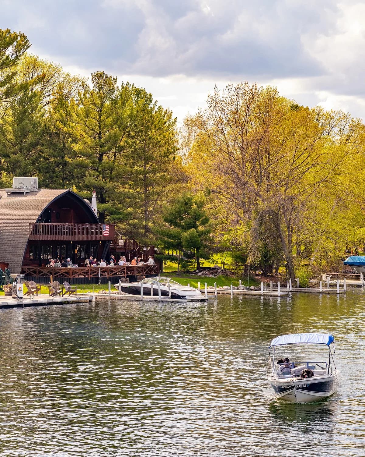 Lakeside scene with a boat on the water and autumn trees