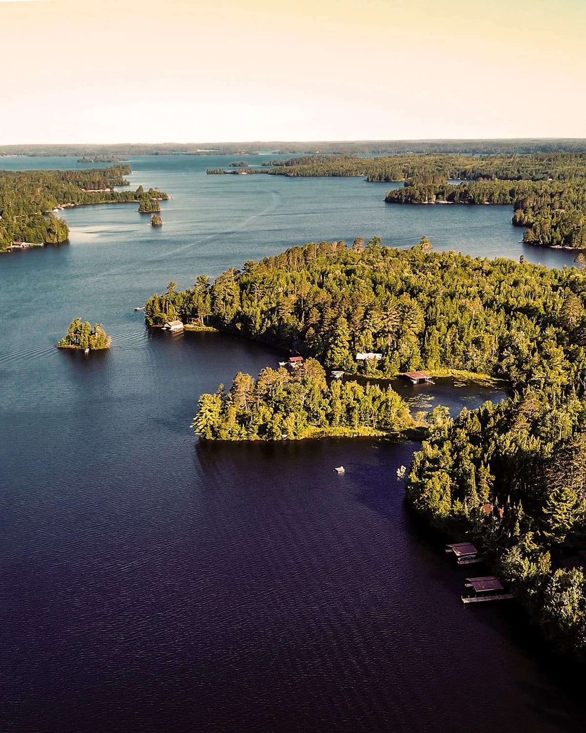 Aerial view of a Minnesota lake with tree-covered islands and docks