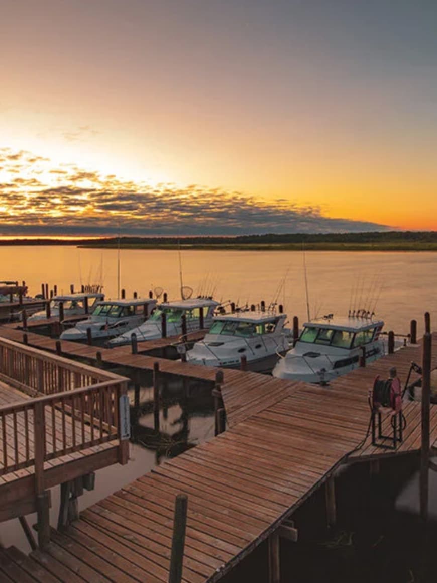 Marina with boats docked at wooden piers during sunset on a calm Minnesota lake